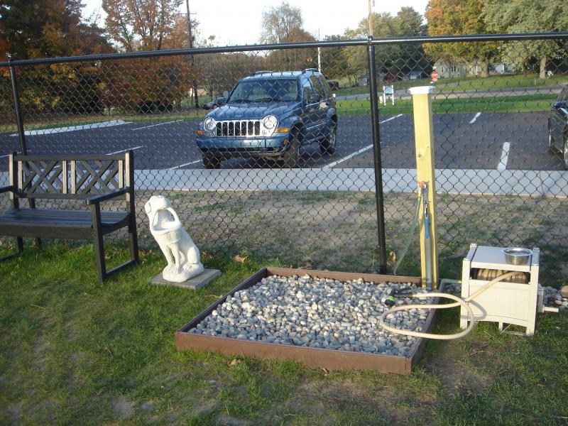 Bench and dog watering station inside a dog park